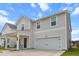 Charming two-story home with a covered front porch, two-car garage, and a manicured lawn at 112 Whisper Dr, Summerville, SC 29485