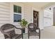 Cozy front porch with wicker chairs and a lush potted plant, perfect for relaxing outdoors at 112 Whisper Dr, Summerville, SC 29485
