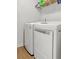 Functional laundry area featuring modern white front-loading washer and dryer with wood-look flooring at 112 Whisper Dr, Summerville, SC 29485