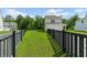 View of the backyard from between a fence featuring an expansive lawn that surrounds the house at 113 Petrell Rd, Summerville, SC 29483
