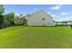 Large backyard surrounded by a black fence featuring a lush lawn under a blue sky with scattered clouds at 113 Petrell Rd, Summerville, SC 29483