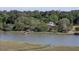 Scenic aerial shot of the property featuring a home, dock, and waterfront views at 1195 Framptons Inlet Rd, Edisto Island, SC 29438