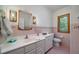 Bright bathroom with white cabinetry, sink, toilet, and window overlooking greenery at 1195 Framptons Inlet Rd, Edisto Island, SC 29438