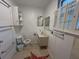 Compact bathroom with a standard toilet, vanity sink, mirrors and a window at 1195 Framptons Inlet Rd, Edisto Island, SC 29438