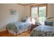 Cozy bedroom featuring two twin beds, soft lighting, and a serene atmosphere with views from the window at 1195 Framptons Inlet Rd, Edisto Island, SC 29438