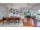 Bright dining room with hardwood floors, views of outdoor scenery, modern lighting, and open access to the kitchen at 1195 Framptons Inlet Rd, Edisto Island, SC 29438