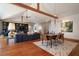 Elegant dining room with an open layout, wooden beams, modern chandelier, and access to living area and kitchen at 1195 Framptons Inlet Rd, Edisto Island, SC 29438
