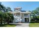 Inviting coastal home with a raised foundation, covered parking, and charming beachside appeal with lush landscaping at 1195 Framptons Inlet Rd, Edisto Island, SC 29438
