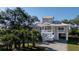 Beautiful elevated home with palm trees, a white stair case, and an attached garage at 1195 Framptons Inlet Rd, Edisto Island, SC 29438