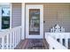 Inviting front door with decorative glass, complemented by a charming wooden porch at 1195 Framptons Inlet Rd, Edisto Island, SC 29438