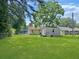 Large, well-maintained backyard featuring a storage shed, mature trees, and green lawn at 1207 Saint Johns Ave, Moncks Corner, SC 29461