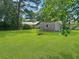 Lush green backyard with a storage shed, mature trees, and ample space for outdoor activities at 1207 Saint Johns Ave, Moncks Corner, SC 29461