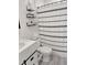 Bright bathroom featuring a shower with patterned curtain, floating shelves and gray wood-look flooring at 1207 Saint Johns Ave, Moncks Corner, SC 29461
