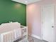 Bright Bedroom with pink and green accent walls, and a white crib at 1207 Saint Johns Ave, Moncks Corner, SC 29461
