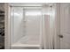 All-white bathroom featuring a tub with a shower and a storage shelf with organized items at 1219 Bradley Blvd, Summerville, SC 29486