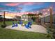Relaxing backyard with gravel fire pit and string lights, surrounded by green lawn and privacy fence at 160 Brookhaven Rd, Summerville, SC 29486