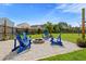 Firepit area with gravel, blue Adirondack chairs, and string lights in a fenced yard at 160 Brookhaven Rd, Summerville, SC 29486
