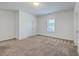 A bright bedroom featuring neutral walls, carpet, a window, and two doors at 175 Darby Meadow Ln, Ridgeville, SC 29472