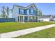 Charming two-story home with a blue exterior, stone accents, and a well-manicured lawn at 175 Darby Meadow Ln, Ridgeville, SC 29472