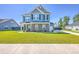 Beautiful two-story home with blue siding, stone accents, and a lush green lawn at 175 Darby Meadow Ln, Ridgeville, SC 29472