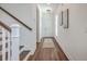 Bright hallway features hardwood floors, white walls, and a staircase with wooden railing at 175 Darby Meadow Ln, Ridgeville, SC 29472