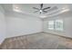 Bright main bedroom boasts plush carpet, a modern ceiling fan, and natural light from a large window at 175 Darby Meadow Ln, Ridgeville, SC 29472