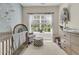 Charming Bedroom featuring a crib, accent wall with bird-themed wallpaper, and bright natural light at 1828 S James Gregarie Rd, Mount Pleasant, SC 29466