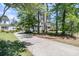 Long driveway lined with mature trees leading to a beautiful home, offering privacy and curb appeal at 1828 S James Gregarie Rd, Mount Pleasant, SC 29466