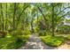 Manicured landscaping and gravel path surrounded by lush trees and greenery at 1828 S James Gregarie Rd, Mount Pleasant, SC 29466