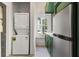 Kitchenette with green cabinets, stainless steel fridge and stacked washer/dryer at 19 Smith St # A, Charleston, SC 29401