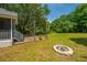Spacious backyard with a wooden deck, lush greenery, mature trees, and a charming fire pit at 1918 Piper Dr, Charleston, SC 29407