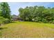 Expansive backyard with lush greenery, mature trees, and a charming house and shed in the background at 1918 Piper Dr, Charleston, SC 29407