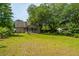 Spacious backyard features lush lawn, mature trees, storage shed, and a quaint screened porch at 1918 Piper Dr, Charleston, SC 29407