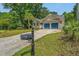 Street view of a single-story home with a well-maintained lawn, driveway, and blue two-car garage at 1918 Piper Dr, Charleston, SC 29407