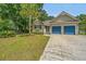 Charming single-story home featuring a two-car garage, driveway and well-manicured lawn with palm tree at 1918 Piper Dr, Charleston, SC 29407