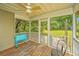 Cozy screened porch with wooden floors, ceiling fan, comfortable seating, and scenic backyard views at 1918 Piper Dr, Charleston, SC 29407