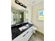 Modern bathroom boasts a sleek vanity, black countertop, large mirror, and glass-enclosed shower at 1991 Joppa Ave, North Charleston, SC 29405