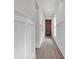 Hallway with white walls and wainscotting, dark wood floor, recessed lighting, and wood door at the end at 1991 Joppa Ave, North Charleston, SC 29405