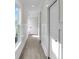 Hallway with white walls, wainscotting, modern doors, light wood floor, and natural light from window at 1991 Joppa Ave, North Charleston, SC 29405