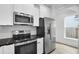 Kitchen boasts stainless steel appliances, white cabinets, black counter tops and a view to the outdoors at 1991 Joppa Ave, North Charleston, SC 29405