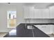 Modern kitchen features black countertops, a stainless steel sink, and bright white cabinets at 1991 Joppa Ave, North Charleston, SC 29405