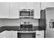 Kitchen with stainless steel appliances, black counter tops and modern white cabinets at 1991 Joppa Ave, North Charleston, SC 29405