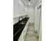 Well-organized pantry boasts white cabinets, black countertops, and stylish wood-look floors at 1991 Joppa Ave, North Charleston, SC 29405