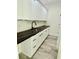 Convenient pantry features white cabinets, sleek black countertops, and wood-look floors at 1991 Joppa Ave, North Charleston, SC 29405