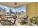 Relax on the screened porch with wicker furniture and views of the picturesque pond and beautiful landscaping at 203 Oak View Way, Summerville, SC 29483
