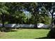 Spacious backyard with large trees, a white privacy fence, and a storage shed at 2233 Glendale Dr, Charleston, SC 29414
