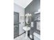 Stylish bathroom with a pedestal sink, black and white tile, and an eye-catching circular mirror at 2468 Marina Rd, Wadmalaw Island, SC 29487