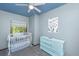 Bedroom featuring a white crib, blue ceiling, and an antique dresser at 2468 Marina Rd, Wadmalaw Island, SC 29487