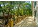 Large outdoor deck with wooden railing, plants, and views of the backyard at 2468 Marina Rd, Wadmalaw Island, SC 29487