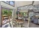 Cozy dining area featuring stylish white shiplap walls, wood floors, and abundant natural light from large windows at 2468 Marina Rd, Wadmalaw Island, SC 29487